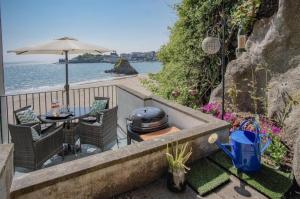 a patio with a grill and a table and chairs at The Sand Castle - 2 Bedroom Apartment - Tenby in Tenby