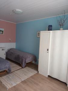 a bedroom with two beds and a white refrigerator at Arens rent Kohtu 2A Apartment in Kuressaare