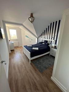 a bedroom with a blue bed and a staircase at Apartament Albatros in Darłowo