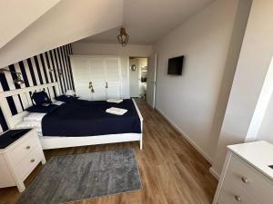 a bedroom with a bed with a blue comforter at Apartament Albatros in Darlowko