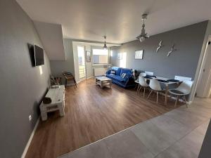 a living room with a blue couch and a table at Apartament Albatros in Darlowko +4 photos