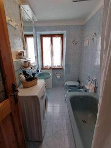a bathroom with a tub and a toilet and a sink at Appartamento sul Liro in Campodolcino