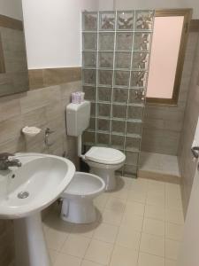 a bathroom with a toilet and a sink at Costa Makauda Residence in Sciacca