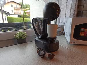 a black coffee maker with a cup on a counter at Family apartments "Hamster" up to 7 persons in Zgornja Polskava