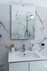 uma casa de banho branca com um lavatório e um espelho em Agriturismo il Casale em Ponte Galeria
