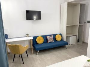 un salon avec un canapé bleu et une télévision dans l'établissement I MORI - Holiday Rooms, à Lascari