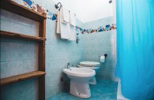a blue bathroom with a toilet and a sink at Villa Di Maria in San Vito lo Capo