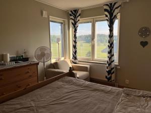 a bedroom with a bed and a chair and a window at An entire floor in a beautiful villa, close to Arlanda Airport in Stockholm