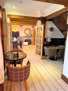 a living room with wooden floors and tables and chairs at Cotswold Merrymouth Inn in Bourton on the Water