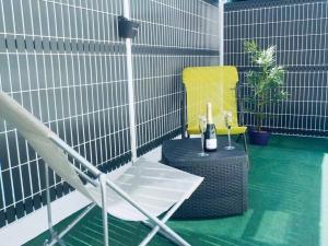 een stoel en een fles wijn op een patio bij La Nuit Coquine - Suite avec Jacuzzi - Evasion in Le Mans