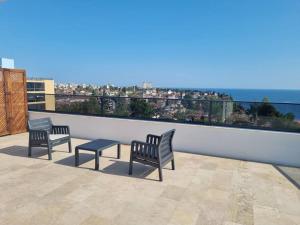 two benches and a table on a balcony overlooking the ocean at Royal Homes 503 in Antalya