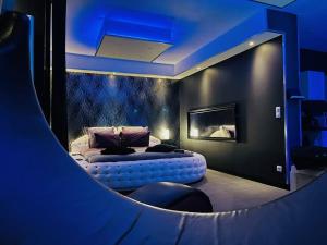 een slaapkamer met een bed in een kamer met blauwe verlichting bij La Nuit Coquine - Suite avec Jacuzzi - Evasion in Le Mans