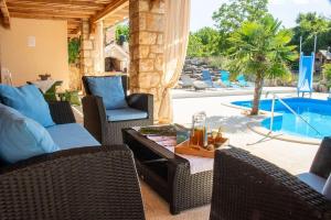 a patio with wicker chairs and a table and a pool at Entspannungsoase - Insel Krk in Rasopasno