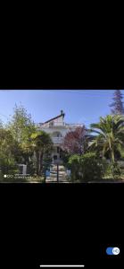 un gran edificio blanco con árboles delante de él en Tatil Evi Triblex, en Atakum