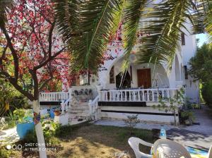 una casa blanca con una palmera delante de ella en Tatil Evi Triblex, en Atakum