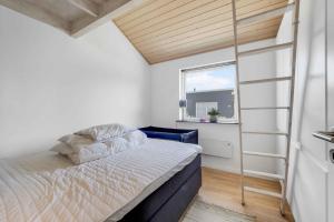 a small bedroom with a bed and a window at Stokholms Sommerhus in Skals