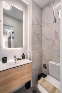 a white bathroom with a sink and a mirror at Konstantina's & Nicol's Studios in Heraklio Town