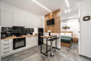 a kitchen with white cabinets and a bed in a room at Konstantina's & Nicol's Studios in Heraklio Town