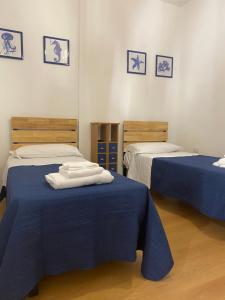 - 2 lits dans une chambre avec des draps bleus dans l'établissement IL FARO in centro vicino Pompei Amalfi Sorrento, à Castellammare di Stabia