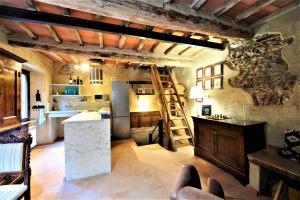 a large kitchen with a ladder and a refrigerator at Incantevole casa sul fiume, Relax e Natura ai piedi della Alpi Apuane in Massa
