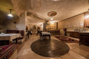 於爾居普的住宿－Konak Bezirhane Cave Otel，一间在房间内配有桌椅的餐厅