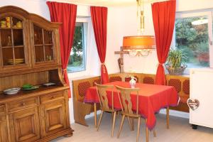 uma sala de jantar com uma mesa vermelha e cadeiras em Charming historical farmhouse em Finning