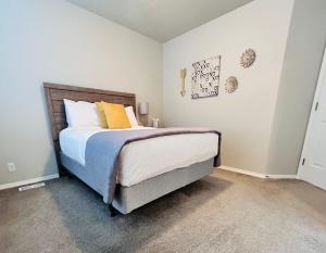 a bedroom with a bed with blue and yellow pillows at The Getaway SE Boise Condo Across the street from Greenbelt, Bown Crossing and Boise River 3BD 3Bath, 4 beds! Lovely, Homey, Dining table seats 6 in Boise