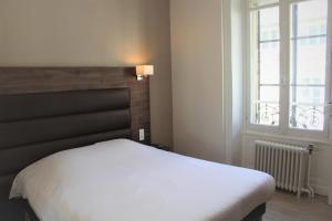 - une chambre avec un lit blanc et une fenêtre dans l'établissement Royal Hôtel Angers, à Angers