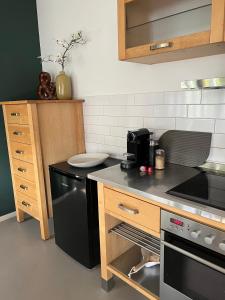 een keuken met een fornuis en een zwarte vaatwasser bij Ruhige Wohnung mit 2 Schlafzimmern auf 80qm in Kürnach