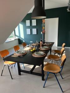 a dining room with a black table and chairs at Ruhige Wohnung mit 2 Schlafzimmern auf 80qm in Kürnach