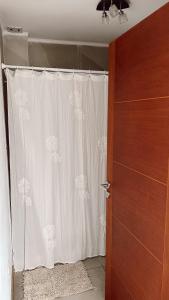 a bathroom with a shower curtain next to a door at El Cerrito departamento in Tandil