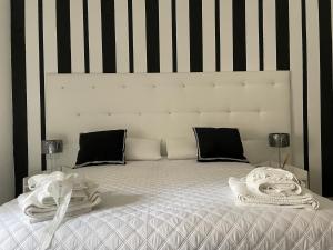 una camera da letto con un letto bianco a righe bianche e nere di Alderì a Matera