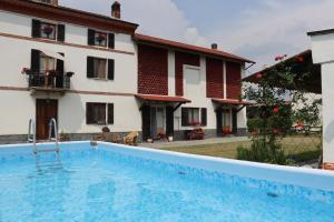 a swimming pool in front of a house at Monferrato Guest House - Casa Gabry in Bruno