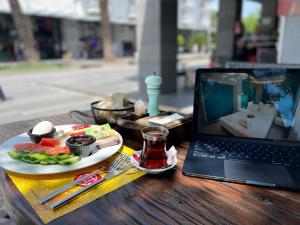 a laptop computer sitting on a table with a plate of food at Sea Front Pansiyon in Antalya