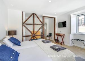 a bedroom with a large white bed with blue pillows at Bairro House Lisbon Charming Suites in Lisbon