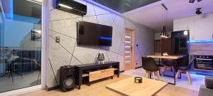 a living room with a television and a table with chairs at Luksusowy Apartament przy Galerii 8th floor in Kielce