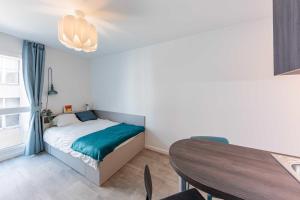 Dormitorio pequeño con cama y mesa en Cute Studio close to Paris - 1P - 509 en Ivry-sur-Seine