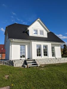 a white house with a black roof at Ferienhaus Mück in Ankershagen