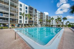 a swimming pool in front of a large apartment building at Coastal Marco Island Condo with Club Amenities! in Marco Island
