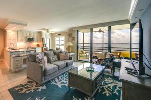 Coastal Marco Island Condo with Club Amenities! في جزيرة ماركو: غرفة معيشة مع أريكة وطاولة