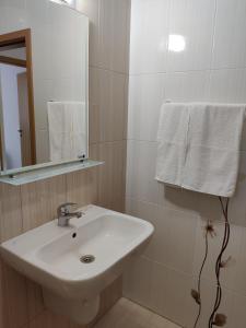 a bathroom with a sink and a mirror and towels at Villa Rossa in Ravda