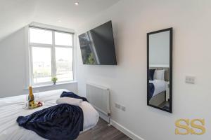 Habitación blanca con cama y espejo en The Hideaway - 1 MINUTE FROM 02 ACADEMY - FREE PARKING - 5 MINUTES FROM THE BEACH - FAST WI-FI - SMART TV, en Bournemouth