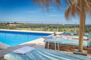 Cette villa dispose d'une piscine et d'une table avec des verres à vin. dans l'établissement Sa Plana Nova, à Portocolom
