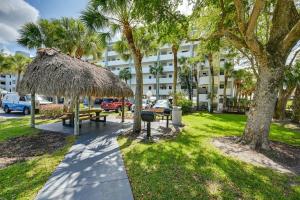 a park with a picnic table and a straw umbrella at Coastal Marco Island Condo with Club Amenities! in Marco Island
