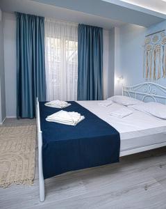 1 dormitorio con 1 cama grande con manta azul en GUEST HOUSE RHEA / КЪЩА ЗА ГОСТИ РЕЯ, en Balchik