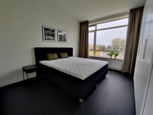 a bedroom with a large bed and a large window at k50159 Spacious and modern apartment near the city center, free parking in Eindhoven