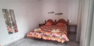 1 dormitorio con 1 cama con colcha colorida en Casitas El Charcon en Arrieta