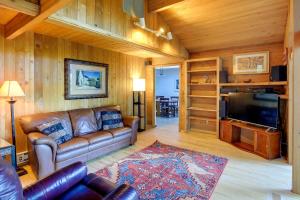 a living room with a leather couch and a flat screen tv at The Fusion Retreat on 4 Acres Hike On-Site! in White Salmon