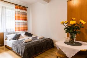 a bedroom with a bed and a table with a vase of flowers at Willa Danuśka in Zakopane