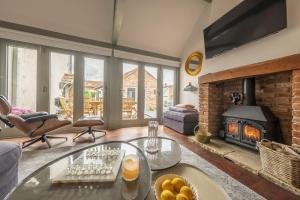 un salon avec une cheminée et une table dans l'établissement Tern Cottage 6, à Burnham Market
